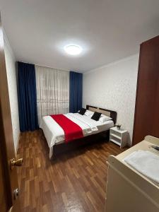 阿克托比Апартаменты в центре города的一间卧室配有一张带红白毯子的床