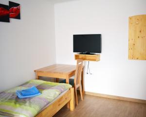 Knežak普里珀札茹农家乐的客房设有一张床、一张书桌和电视