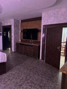 Tourista Travel and Tours的带平面电视的客厅和带紫色墙壁的房间。