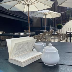 亚布卢尼齐亚Котеджі Лісові Форелі的桌子上的一本书,上面有茶壶和笔记本电脑
