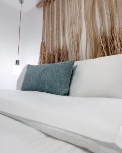 El RoqueSabbia By LD Hoteles的一张白色的床,上面有蓝色的枕头
