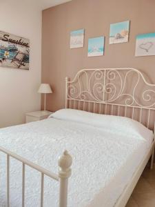 波尔图·埃尔科莱La casa di Ieia的卧室内的一张床铺,配有白色床架