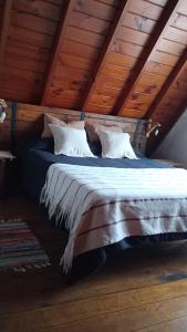 马德普拉塔Cabaña,Chalet Alpino Bosques de Peralta Ramos的木制天花板的客房内的一张大床