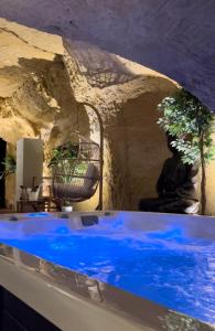 吕讷Hôtel-Restaurant-Chambre Insolite Spa - Le XII de Luynes的石头墙房里的一个蓝色的水池