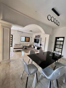 科托努Sublime Villa的客厅配有黑色的桌子和椅子