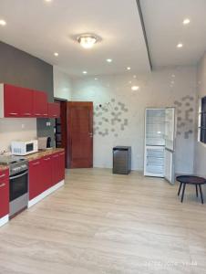 科托努Sublime Villa的一个带红色橱柜和桌子的大厨房