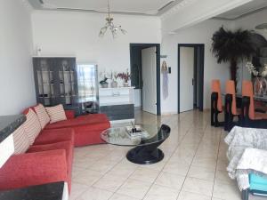 卡瓦拉Rafaela's Apartment的客厅配有红色的沙发和桌子