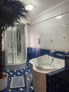 卡瓦拉Rafaela's Apartment的带浴缸和棕榈树的浴室