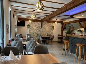 弗勒里耶Hotel Restaurant du Moulin的一间带桌椅的餐厅以及砖墙