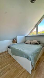 奈达Nida Oasis Apartment的白色客房的一张床位,设有两个窗户
