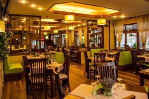 锡纳亚里维埃拉酒店的餐厅设有木桌和绿色椅子