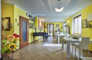 曼德洛德拉廖B&B-FORESTERIA Casa Della Musica Lake Como的一间拥有黄色墙壁和钢琴的用餐室