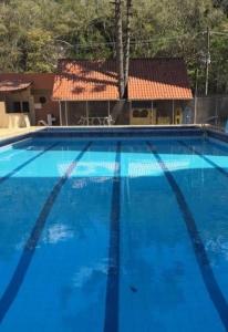 卡尚布Hospedagem Sul de Minas Caxambu的一座蓝色的大型游泳池,其建筑背景为:
