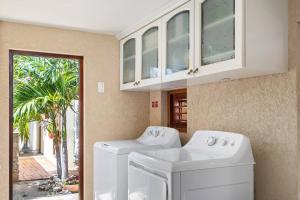 SavanetaVilla Laurence Aruban Oasis Footsteps To Ocean的洗衣房设有两台洗衣机和一扇窗户