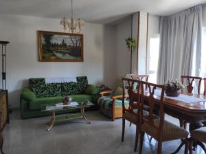 圣拉菲尔Residencial Pinar San Rafael (VuT)的客厅配有绿色沙发和桌子