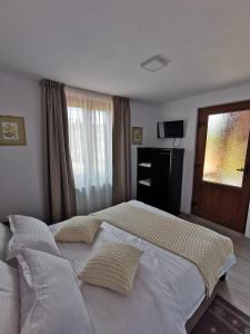 Sita BuzăuluiCABANA VALEA POPII的卧室配有一张带两个枕头的大白色床