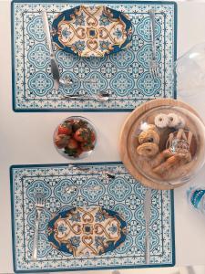 圣贝内代托-德尔特龙托Acasadelpescatore的一张铺有蓝色和白色瓷砖的桌子和一碗食物