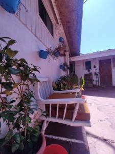 埃尔基斯科Hostal Saint Michell. El Quisco的坐在大楼旁边的白色长凳