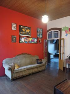 欧鲁普雷图Brumas Ouro Preto Hostel e Pousada的客厅配有靠红墙的沙发