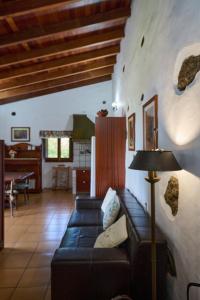 莫卡诺尔Casa Rural Tia Lucila的客厅配有黑色沙发和桌子
