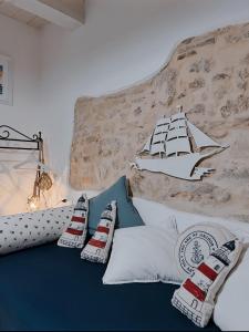 圣贝内代托-德尔特龙托Acasadelpescatore的一张带枕头的床和墙上的船