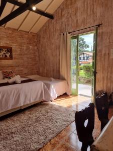 蒙特韦尔迪Pousada Brisa da Mantiqueira的一间卧室设有两张床和滑动玻璃门