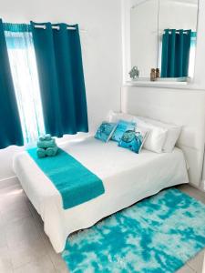 宏达海滩Casa Yurena的白色的床,配有蓝色枕头和蓝色窗帘