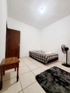 坎皮纳斯Suíte Proença的一间卧室配有一张床、一张桌子和一张地毯。