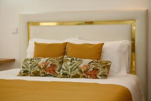 卡尔达斯达·赖尼亚Nova Delpa AL的一张带白色床头板和一些枕头的床