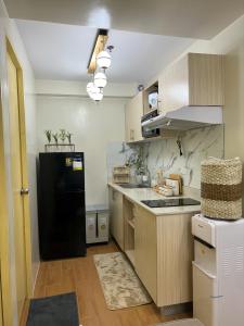 BabakScarlet Suites Condominium的厨房配有黑色冰箱和木制橱柜。