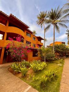 TucacasUn Oasis entre Olas y Palmeras con Playa Privada的棕榈树和鲜花的房子