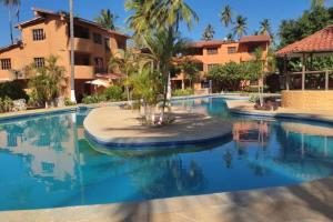 TucacasUn Oasis entre Olas y Palmeras con Playa Privada的中间的棕榈树度假村游泳池