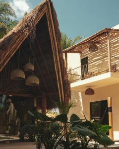 埃尔库约Nikau Hotel El Cuyo - Adults Only的茅草屋顶和阳台的房子
