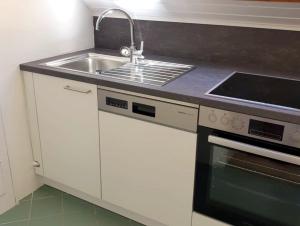 沃尔特湖畔韦尔登Seeappartements Excelsior的厨房配有水槽和炉灶
