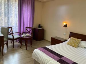 埃里温DaMus apartments的酒店客房,配有床、桌子和椅子