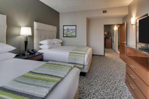 萨凡纳Drury Plaza Hotel Savannah Pooler的酒店客房设有两张床和一台平面电视。