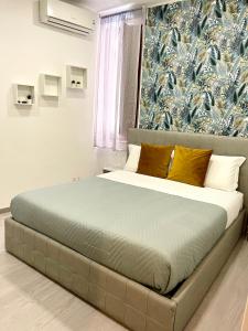 陶尔米纳Domus Cuseni的卧室内的一张床铺,配有蓝色和白色的壁纸