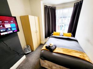 赫尔Stay Sleep Rest - De Grey的一间卧室设有一张带平面电视的床。