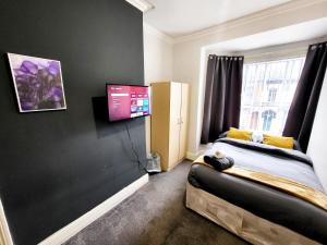 赫尔Stay Sleep Rest - De Grey的一间卧室配有一张床和一台平面电视