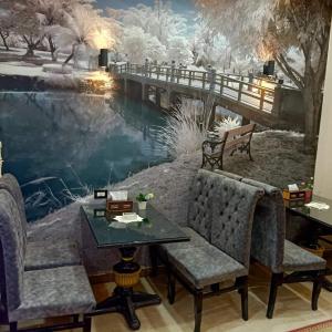 索哈杰Dahab hotel的一间房间,在冬季壁画前配有桌椅