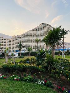 艾因苏赫纳Chalet in Porto Sokhna Beach Resort的一座种植了棕榈树和鲜花的大建筑