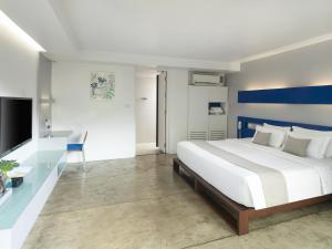 哈林海滩Explorar Koh Phangan - Adults Only Resort and Spa的卧室配有白色的床和蓝白色的墙壁