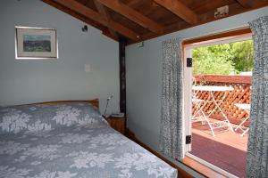 凯库拉迪伦山林小屋的一间卧室设有一张床和一个滑动玻璃门