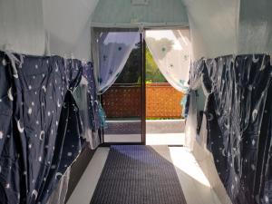 道伊斯Riu del Mar Hostel的一间设有蓝色窗帘的客房和一扇带窗户的门