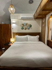 圣巴勃罗Diwata Nature Resort的卧室配有白色大床和灯