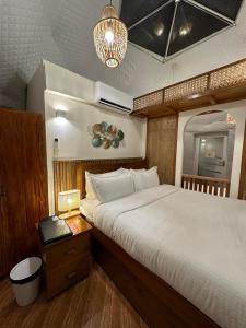 圣巴勃罗Diwata Nature Resort的一间卧室配有一张大床和一个带四柱床的床头柜。