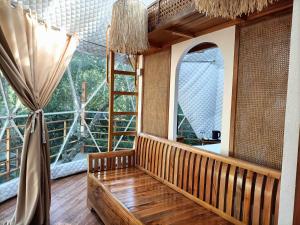 圣巴勃罗Diwata Nature Resort的客房设有大窗户和木凳