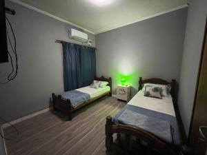 卡塔马卡FR ALOJAMIENTOS, rojas 329的一间卧室设有两张床,享有绿光。