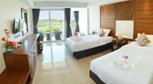 奈扬海滩David Residence的酒店客房设有两张床和电视。