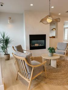 彭蒂克顿Balcomo - A Ramada By Wyndham的客厅配有两把椅子、一张桌子和壁炉